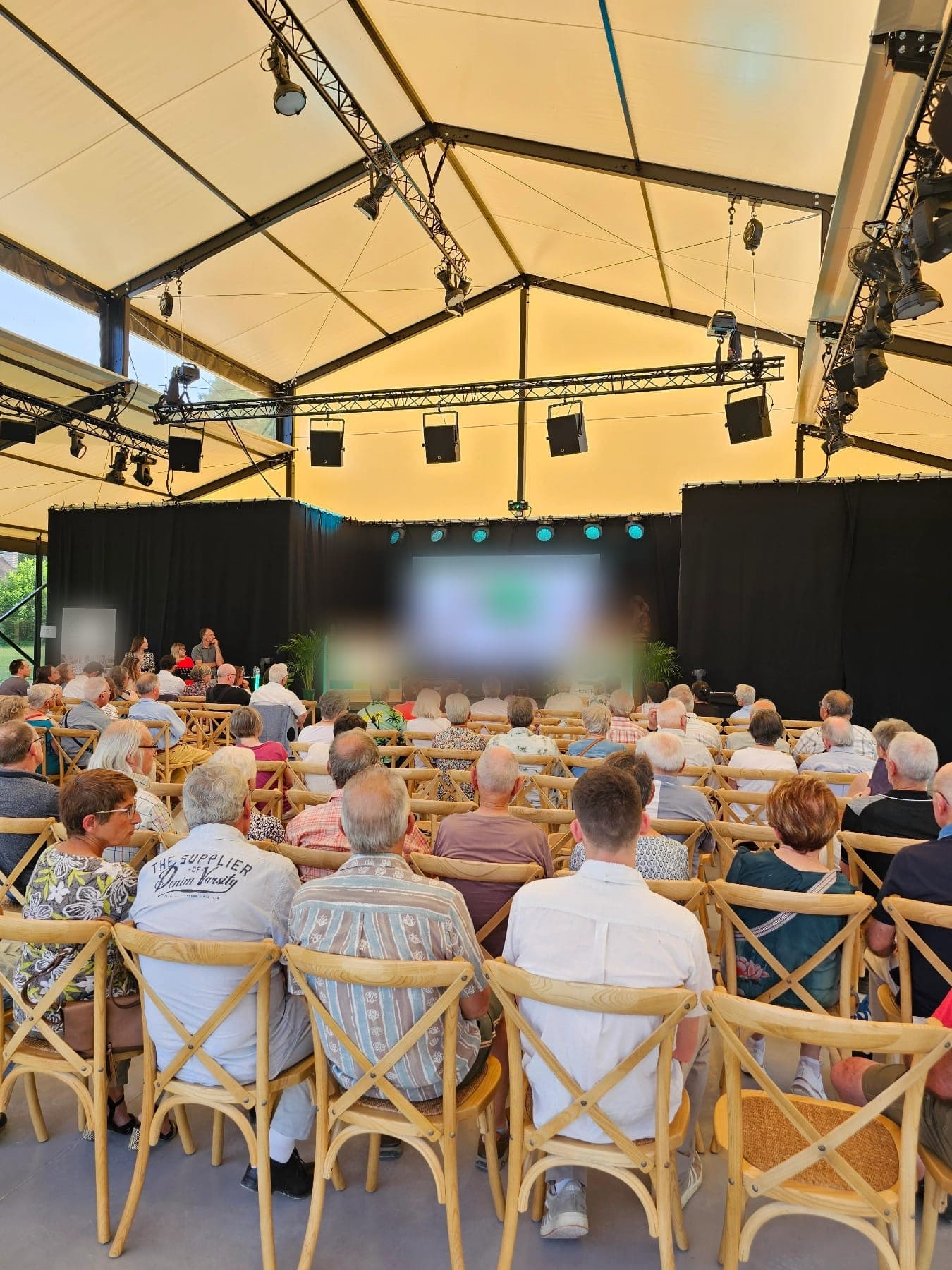Une conférence sous l'Orangerie, devant un public assis